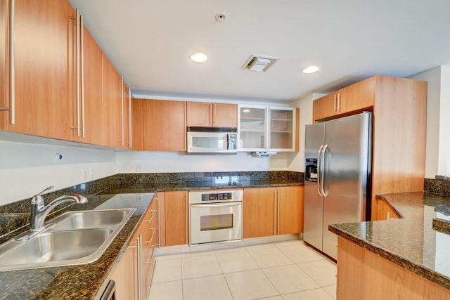 610 Clematis St Unit 638, West Palm Beach, FL 33401 - kitchen featuring stainless steel appliances, dark stone countertops, light tile patterned floors, glass insert cabinets, and recessed lighting