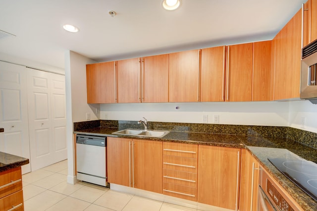 kitchen featuring dark stone counters, black electric cooktop, white dishwasher, sink, and light tile patterned floors