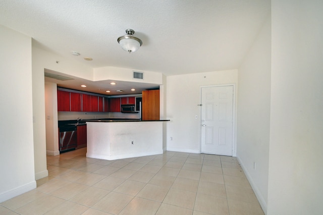 kitchen with kitchen peninsula, light tile patterned floors, a textured ceiling, and appliances with stainless steel finishes