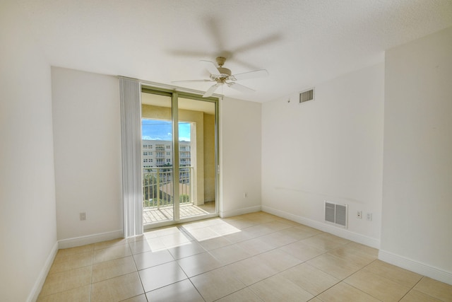 tiled spare room featuring a textured ceiling and ceiling fan