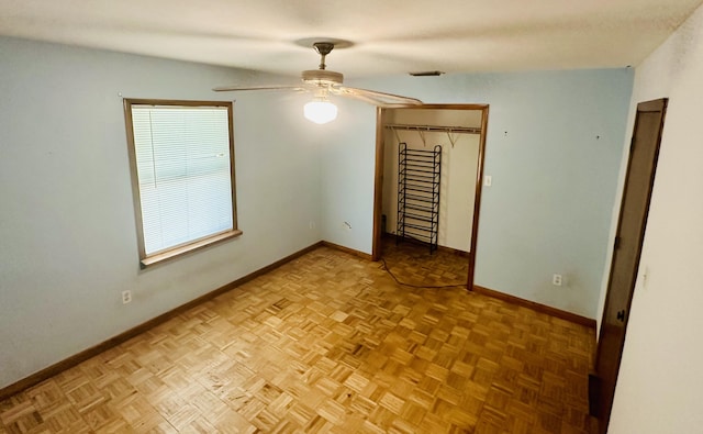 unfurnished bedroom featuring light parquet flooring and ceiling fan