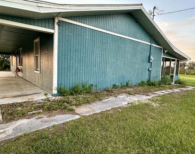 property exterior at dusk featuring a yard