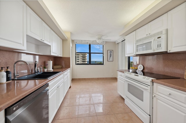 kitchen featuring ceiling fan, sink, light tile patterned floors, white appliances, and white cabinets