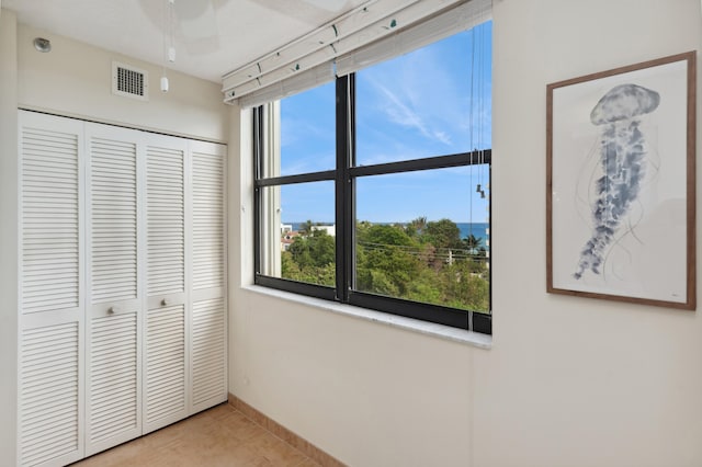 unfurnished bedroom with ceiling fan, a closet, and light tile patterned flooring