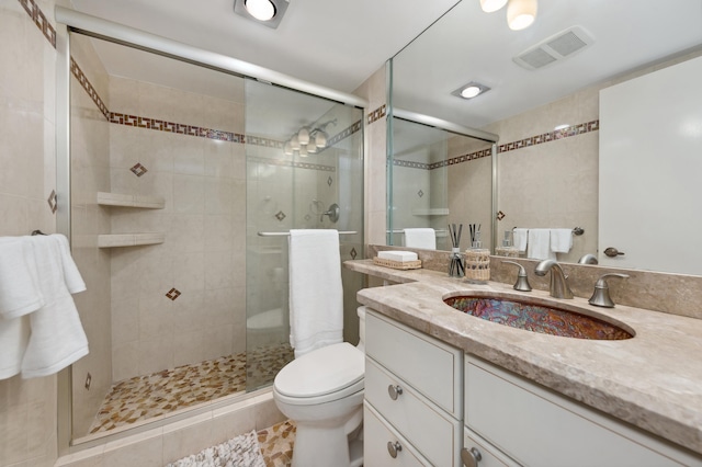 bathroom with tile patterned flooring, vanity, a shower with door, and toilet