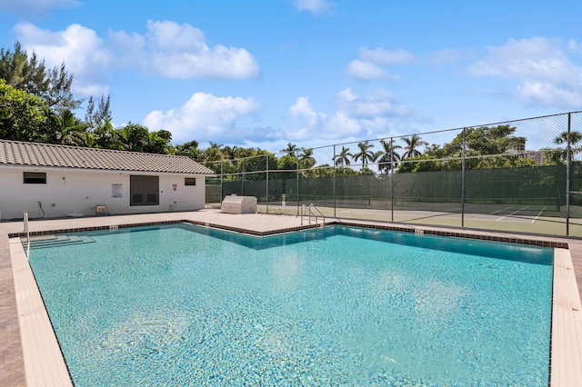 view of pool with tennis court