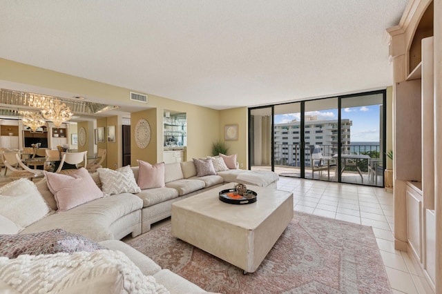 living room featuring plenty of natural light, floor to ceiling windows, light tile patterned floors, and a textured ceiling