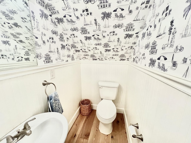 bathroom with toilet, sink, and hardwood / wood-style flooring