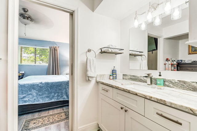 bathroom featuring hardwood / wood-style flooring, ceiling fan, and vanity