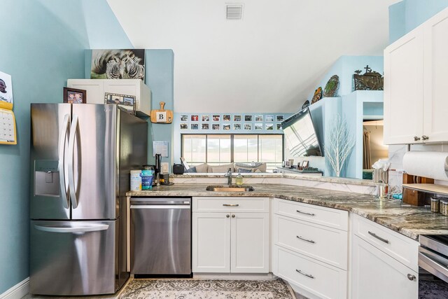 kitchen featuring white cabinetry, stainless steel appliances, sink, and light stone counters