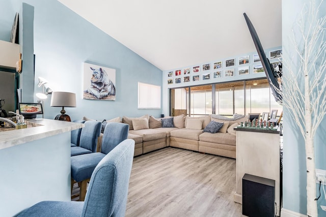 living room featuring light hardwood / wood-style flooring and high vaulted ceiling