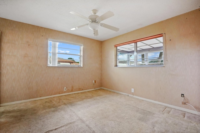 carpeted spare room with ceiling fan