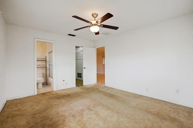 unfurnished bedroom featuring carpet flooring, ceiling fan, ensuite bathroom, a walk in closet, and a closet