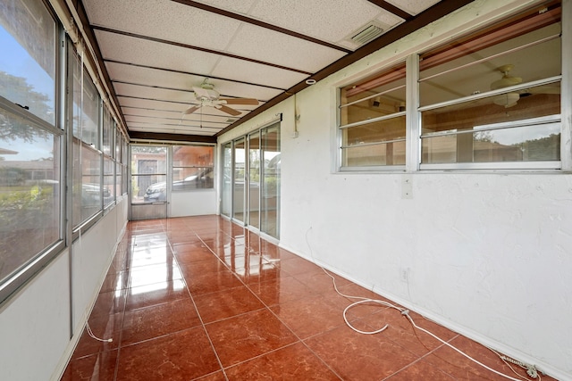 unfurnished sunroom featuring a paneled ceiling and ceiling fan