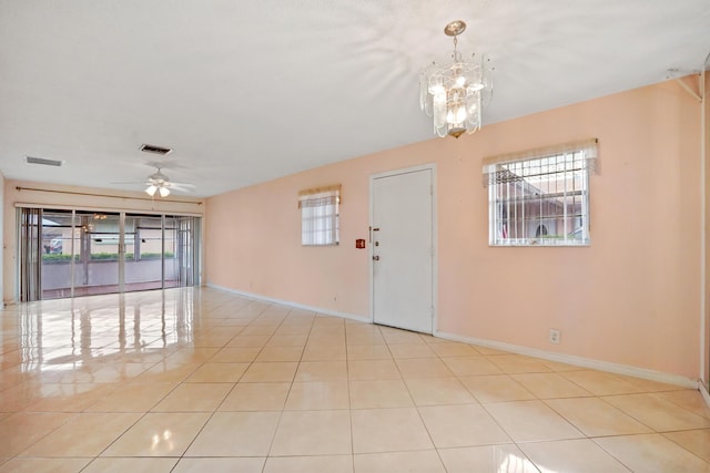 foyer entrance featuring light tile patterned floors and ceiling fan with notable chandelier