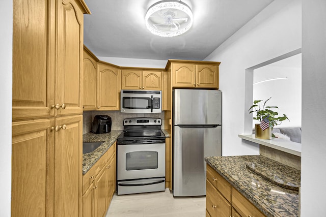 kitchen with tasteful backsplash, stainless steel appliances, and dark stone countertops