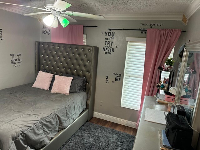 bedroom with a textured ceiling, ceiling fan, wood-type flooring, and crown molding