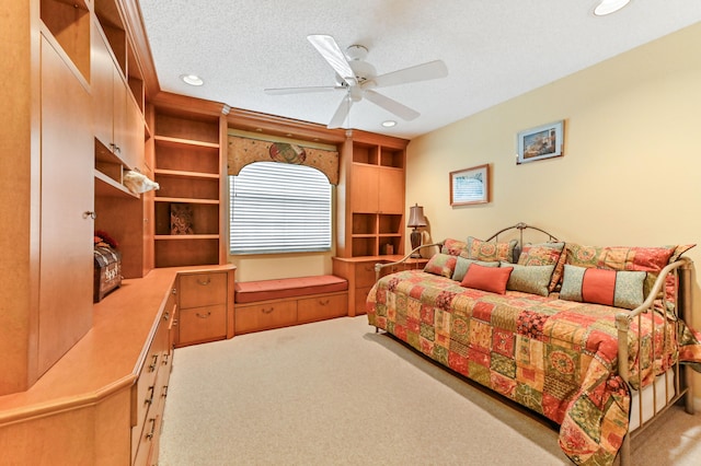 carpeted bedroom with ceiling fan and a textured ceiling