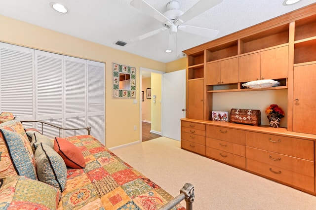 bedroom with ceiling fan, a textured ceiling, and a closet