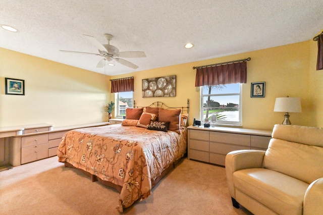 carpeted bedroom featuring a textured ceiling and ceiling fan