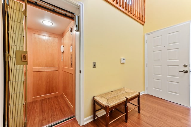 foyer entrance with hardwood / wood-style flooring and elevator