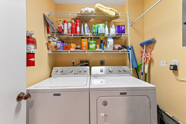 laundry room with washing machine and clothes dryer and a textured ceiling