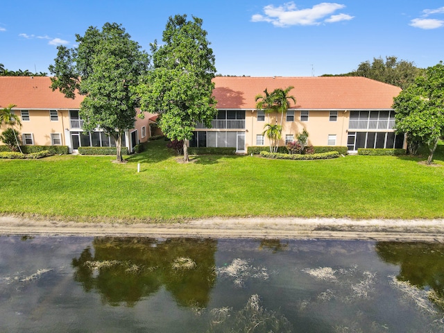 exterior space featuring a lawn and a water view