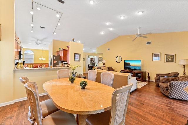 dining room featuring hardwood / wood-style flooring, ceiling fan, lofted ceiling, and track lighting