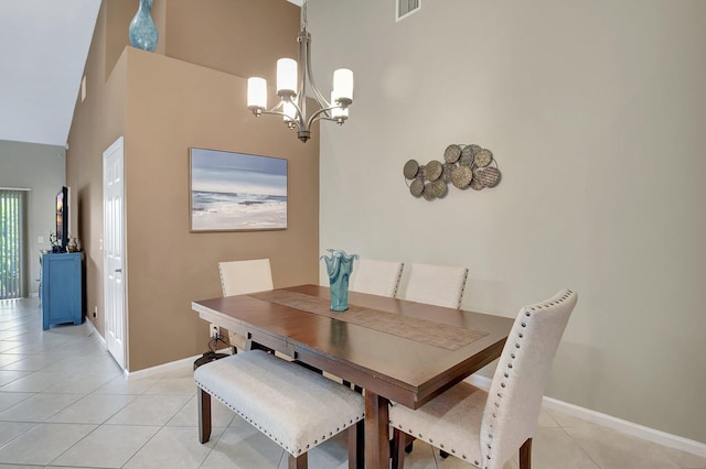 tiled dining space with a chandelier and a high ceiling