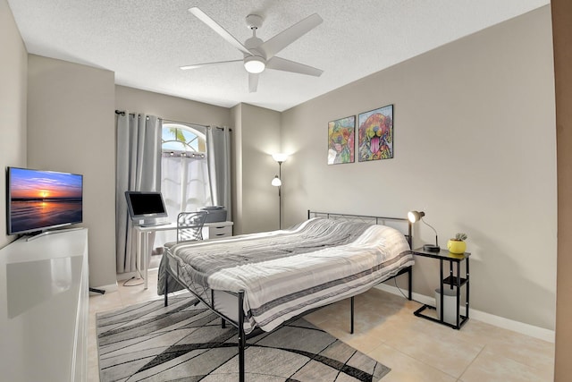 tiled bedroom featuring ceiling fan and a textured ceiling