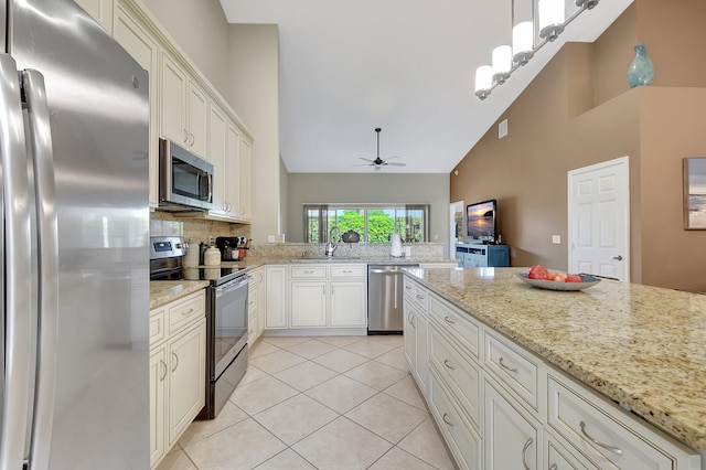 kitchen featuring pendant lighting, high vaulted ceiling, ceiling fan, appliances with stainless steel finishes, and light tile patterned flooring