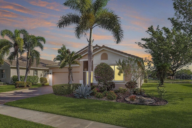 view of front of house with a garage and a yard