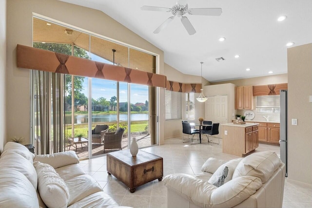 living room with a water view, sink, light tile patterned floors, and lofted ceiling