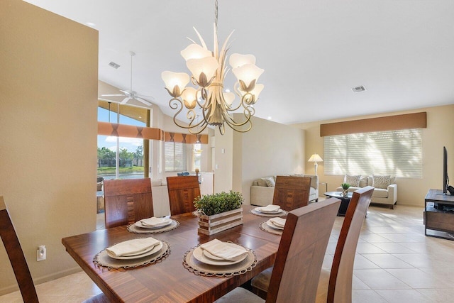 dining area featuring lofted ceiling, light tile patterned floors, ceiling fan with notable chandelier, and plenty of natural light