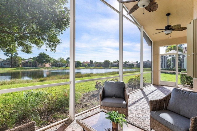 sunroom featuring ceiling fan and a water view