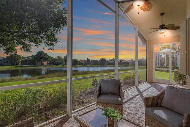 sunroom with a water view and ceiling fan