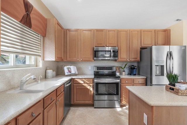 kitchen featuring light tile patterned flooring, appliances with stainless steel finishes, sink, and backsplash