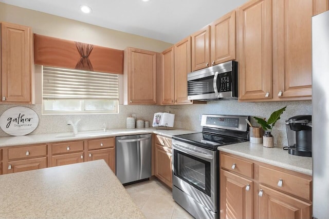 kitchen featuring tasteful backsplash, appliances with stainless steel finishes, sink, and light tile patterned floors