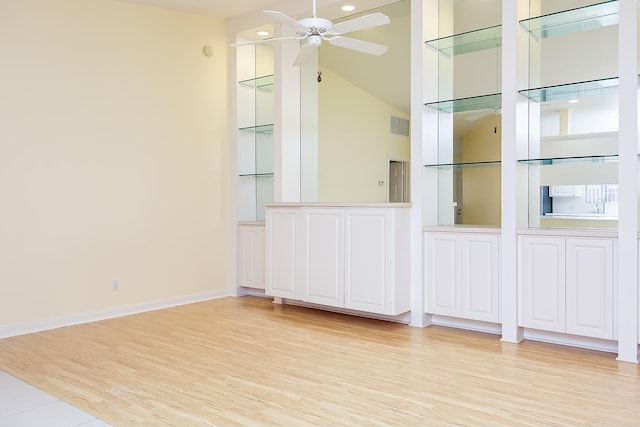 interior space with a high ceiling, light wood-type flooring, and ceiling fan