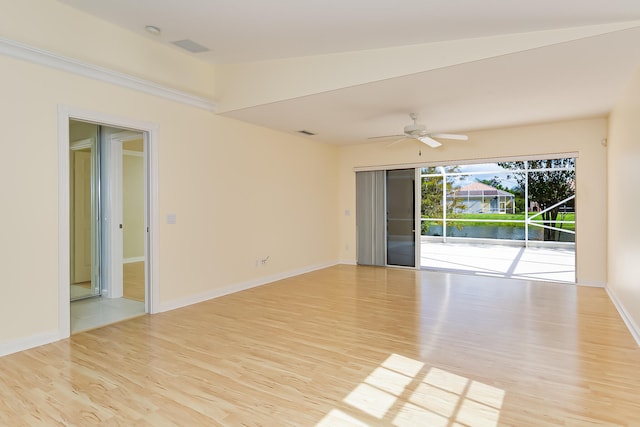 unfurnished room featuring ceiling fan, light hardwood / wood-style flooring, a water view, and vaulted ceiling