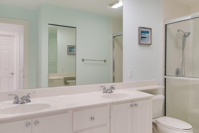 bathroom featuring vanity, toilet, and a shower with door