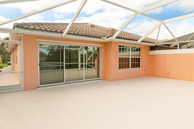 rear view of property with a patio and glass enclosure