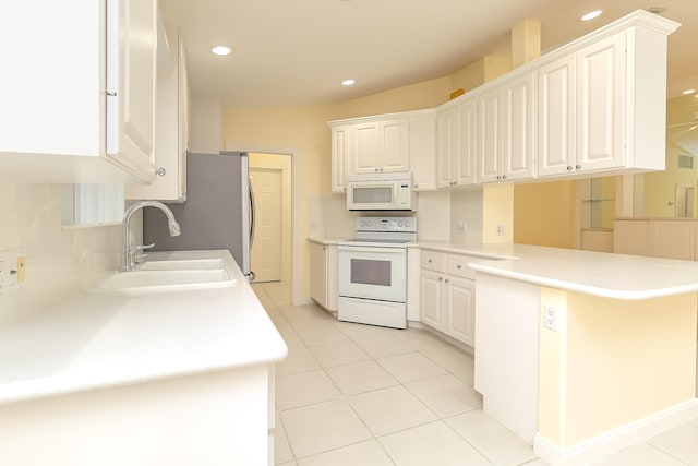 kitchen with kitchen peninsula, white appliances, white cabinets, and sink