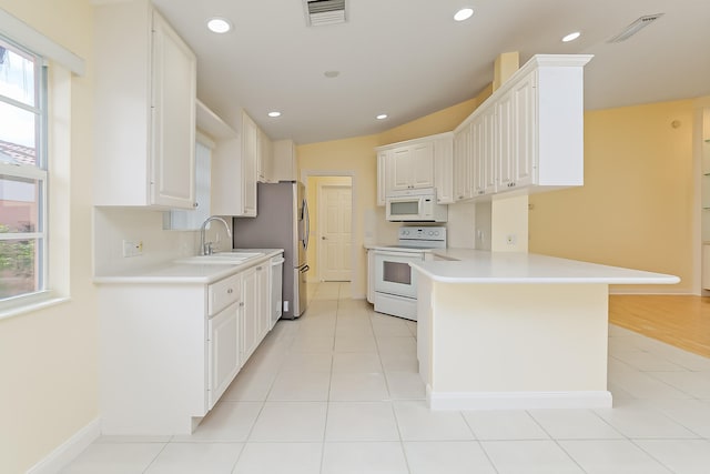 kitchen featuring kitchen peninsula, white appliances, white cabinetry, and sink