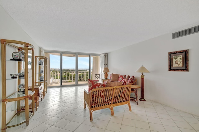 living room featuring floor to ceiling windows, light tile patterned floors, and a textured ceiling