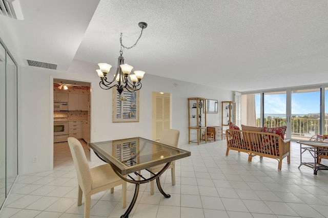 dining room featuring light tile patterned flooring, a chandelier, and a textured ceiling