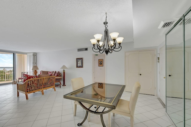 tiled dining room featuring a chandelier and a textured ceiling