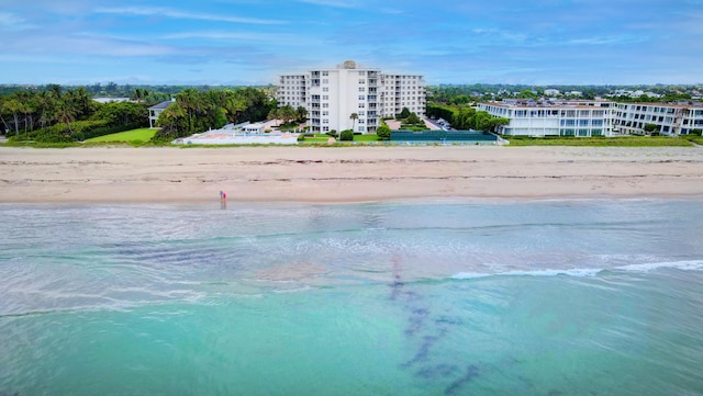 drone / aerial view with a water view and a beach view