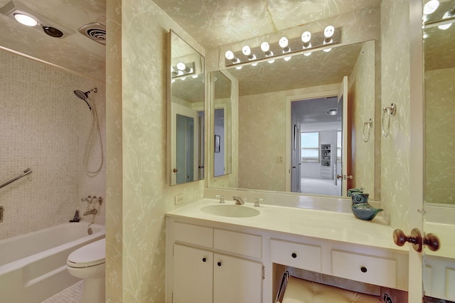 full bathroom with toilet, vanity, and tiled shower / bath combo