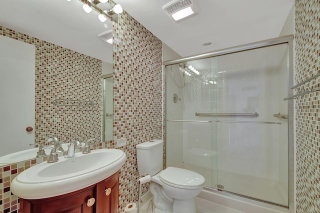 bathroom featuring walk in shower, vanity, toilet, and tile walls